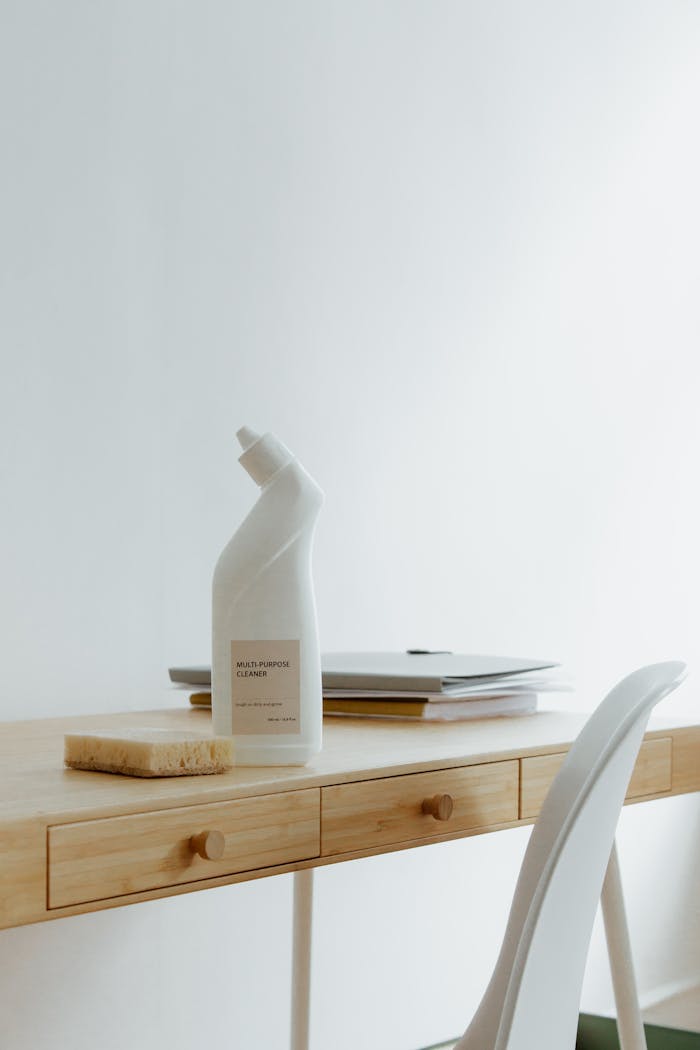services-02 A clean and organized home office desk with a cleaner bottle and sponge, emphasizing simplicity and functionality.