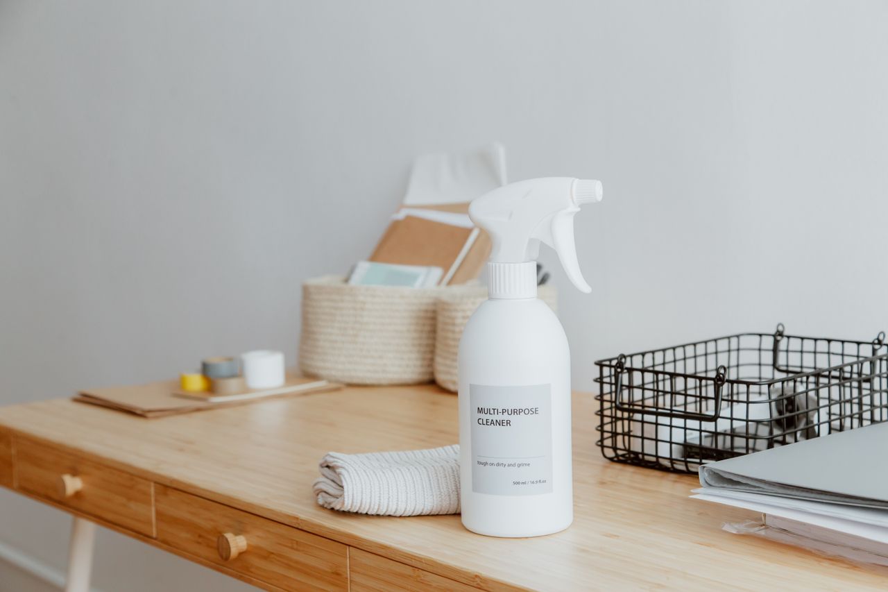 why-choose-us Minimalist desk with a focus on a multipurpose cleaner, office supplies, and storage solutions.